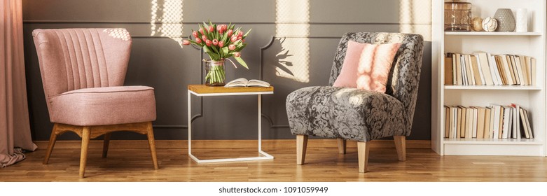 Stylish Reading Room Interior With Two Armchairs, End Table With Flowers And Rack With Books