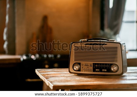 a stylish retro radio player stands on a wooden table. stylish kitchen in the village, daylight from the window. copy space