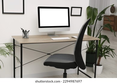 Stylish room interior with comfortable office chair, desk and houseplants - Shutterstock ID 2294987697