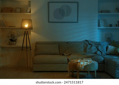 Stylish room interior with couch and lamp at night - Powered by Shutterstock