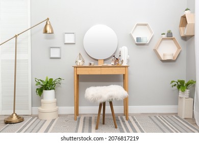 Stylish room interior with wooden dressing table and mirror on light wall - Powered by Shutterstock