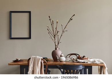 Stylish rustic interior of dining room with walnut wooden table, retro chairs, decoration, dried flower in vase and mock up picture frame in minimalist home decor. Template. - Shutterstock ID 1965086986