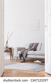 Stylish Scandi Interior Of Home Space With Design Grey Sofa And Retro Small Table. Living Room With Design Accessories And Mock Up Poster Frame. Elegant Decor. Brown Wooden Parquet With Modern Carpet.