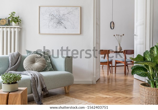 Stylish scandinavian living room with design mint sofa,
furnitures, mock up poster map, plants and elegant personal
accessories. Modern home decor. Open space with dining room.
Template Ready to use. 