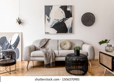 Stylish And Scandinavian Living Room Interior Of Modern Apartment With Gray Sofa, Pillows, Plaid, Plants, Design Wooden Commode, Black Table, Lamp, Abstrac Paintings On The Wall.  Modern Home Decor.