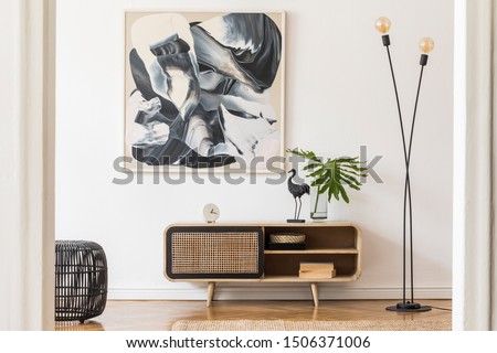 Stylish scandinavian living room interior with modern wooden commode, stylish lamps, plants, rattan basket, sculpture and elegant personal accessories. Mock up paintings on the white wall. Template. 