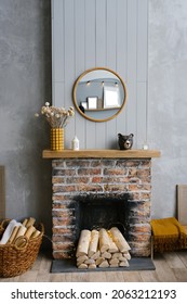 Stylish Scandinavian Minimalist Interior With A Brick Fireplace And Wood Fire. Cozy House. The Modern Interior Of The Country House Is Decorated In Gray And Mustard Colors.  Round Mirror