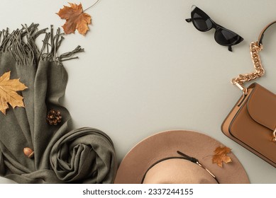 Stylish seasonal accessories. Top view shot presenting a trendy felt hat, cozy scarf, elegant gloves, and a chic handbag on light grey background with empty frame for fashion-forward promotions - Shutterstock ID 2337244155
