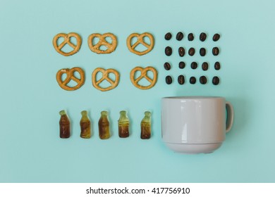 Stylish set: pretzel, jelly in shape of bottles, cup and coffee beans on pastel blue backgrouns. Flat lay. Top view. - Powered by Shutterstock