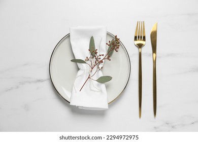 Stylish setting with cutlery and eucalyptus leaves on white marble table, flat lay - Shutterstock ID 2294972975