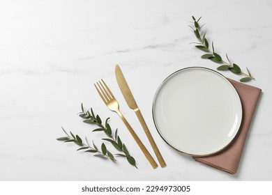 Stylish setting with cutlery and eucalyptus leaves on white marble table, flat lay. Space for text - Powered by Shutterstock