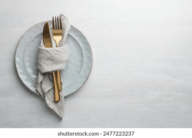 Stylish setting with cutlery, napkin and plates on white table, top view. Space for text - Powered by Shutterstock