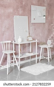 Stylish Shelf With Peg Board On Pink Textured Wall Background