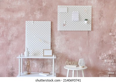 Stylish Shelf Unit With Peg Board On Pink Textured Wall Background