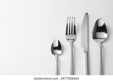 Stylish silver cutlery on white background, flat lay. Space for text - Powered by Shutterstock