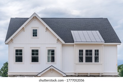 Stylish Single Family House Facade With White Vertical Vinyl Siding, Gable With Attic Window And Decorative Brackets