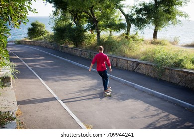 stylish skater in red shirt and blue jeans ride downhill on longboard, summer active picture  - Shutterstock ID 709944241