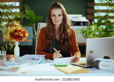 Stylish Small Business Owner Woman With Autumn Yellow Leaves In The Modern Green Office.