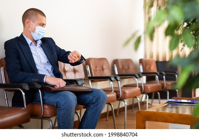 Stylish Successful Man In Face Mask With Briefcase Waiting For Job Interview In Office Lobby