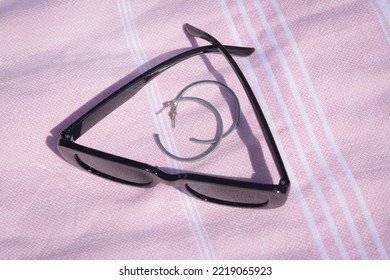 Stylish Sunglasses And Jewelry On Pink Blanket, Above View