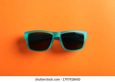 Stylish Sunglasses On Orange Background, Top View