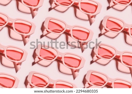 Stylish sunglasses pink color glasses on light pink background, shadow at sunlight, summer fashion eyeglasses. Summer sale concept in optical store. Top view aesthetic pattern, monochromatic flat lay