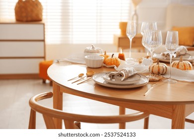 Stylish table setting with beautiful dishware and autumn decor in dining room