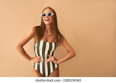  A stylish tanned woman on a beige background is smiling.                               - Powered by Shutterstock