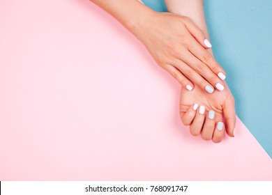 Stylish trendy female manicure. Beautiful young woman's hands on pink and blue background. - Shutterstock ID 768091747