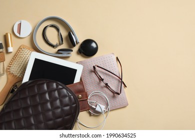 Stylish urban backpack with different items on beige background, flat lay. Space for text