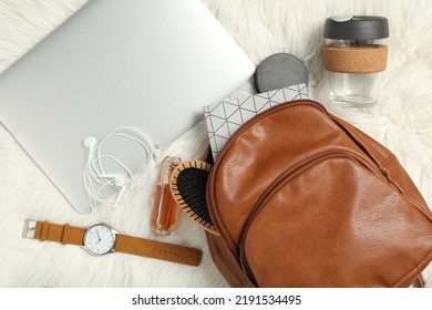 Stylish Urban Backpack And Different Items On White Faux Fur, Flat Lay