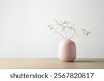 Stylish vase with beautiful branches on wooden table, space for text