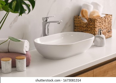 Stylish vessel sink on light countertop in modern bathroom