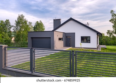 Stylish villa with fence, garage and lawn, exterior view