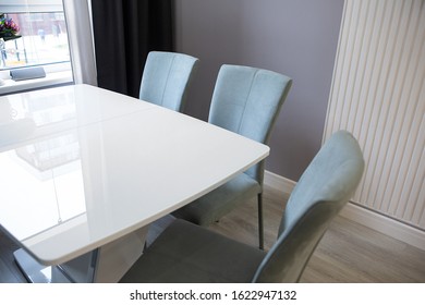 Stylish white glossy small dining table with chairs in a compact bright kitchen