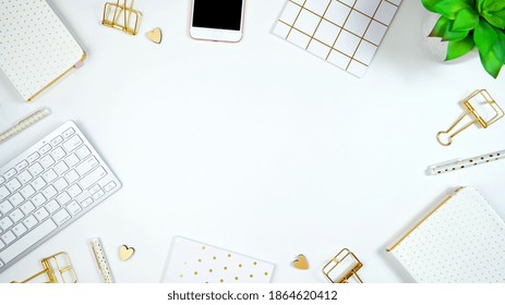 Stylish white and gold theme desktop workspace with keyboard, notebooks and smart phone. Top view blog hero header creative composition flat lay. - Shutterstock ID 1864620412