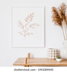 Stylish white interior of living room with mock up poster frame, rattan decoration, leaf, wooden shelf, dried flowers and elegant personal stuff. Neutral concept of home decor. Template.