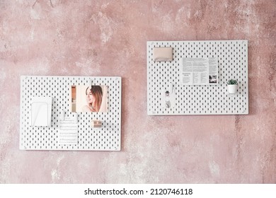 Stylish White Peg Board Hanging On Textured Pink Wall