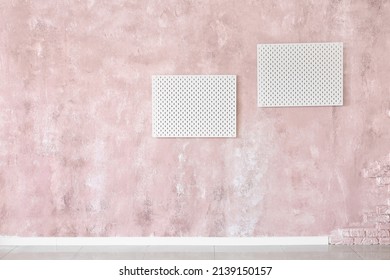 Stylish White Peg Board Hanging On Textured Pink Wall