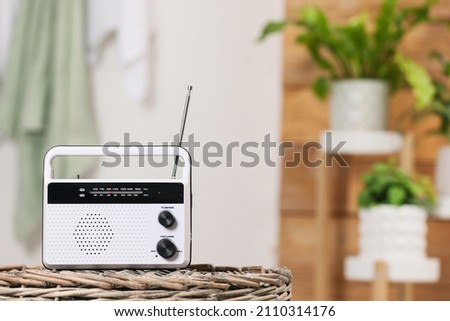 Stylish white radio on wicker stand indoors, space for text