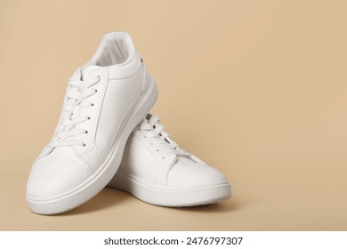 Stylish white sneakers on beige background - Powered by Shutterstock