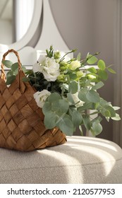 Stylish Wicker Basket With Bouquet Of Flowers On Ottoman In Room