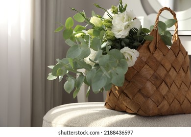 Stylish Wicker Basket With Bouquet Of Flowers On Ottoman In Room