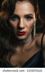 stylish woman in classic retro style of 1950s Hollywood movies with a beautiful hairstyle and makeup. Portrait of girl in vintage look with jewelry on dark background