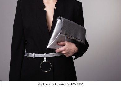 Stylish woman hold silver clutch bag isolated on gray background