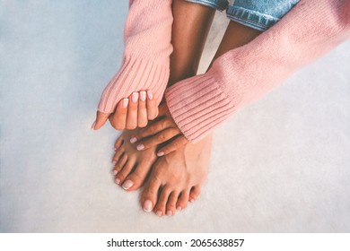 Stylish Woman In Pink Sweater Showing Her Beautiful Nails With French Manicure And Pedicure. Nails After Manicure And Pedicure Treatment. Copy Space