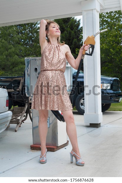 Stylish\
woman prepares to pump gas at a service\
station