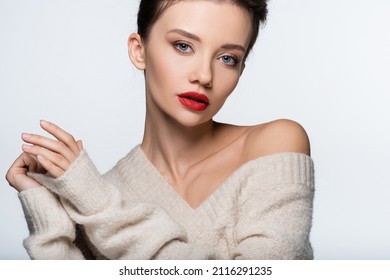 Stylish woman with red lips in warm sweater looking at camera isolated on white