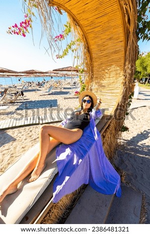 Stylish Woman Relaxing in a Beach Cabana with a Sea View on a Sunny Day