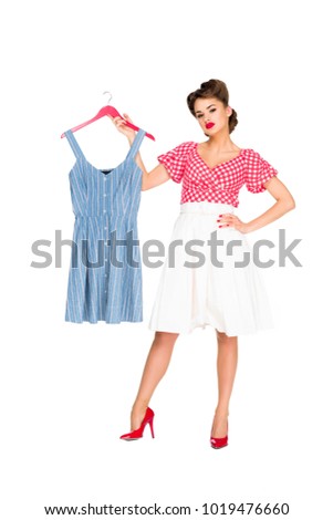 stylish woman in retro clothing holding dress on hanger isolated on white